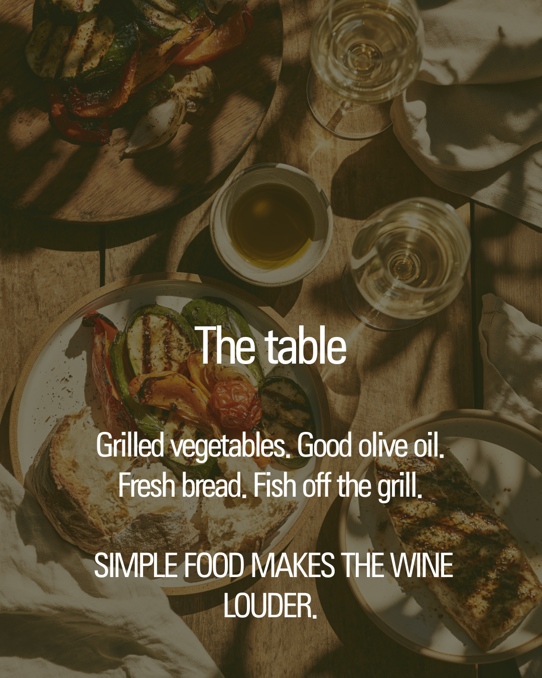 Simple grilled meal and white wine on a wooden table.